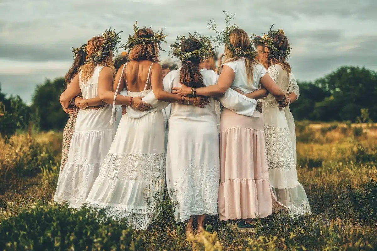 Women in flower wreath on sunny meadow