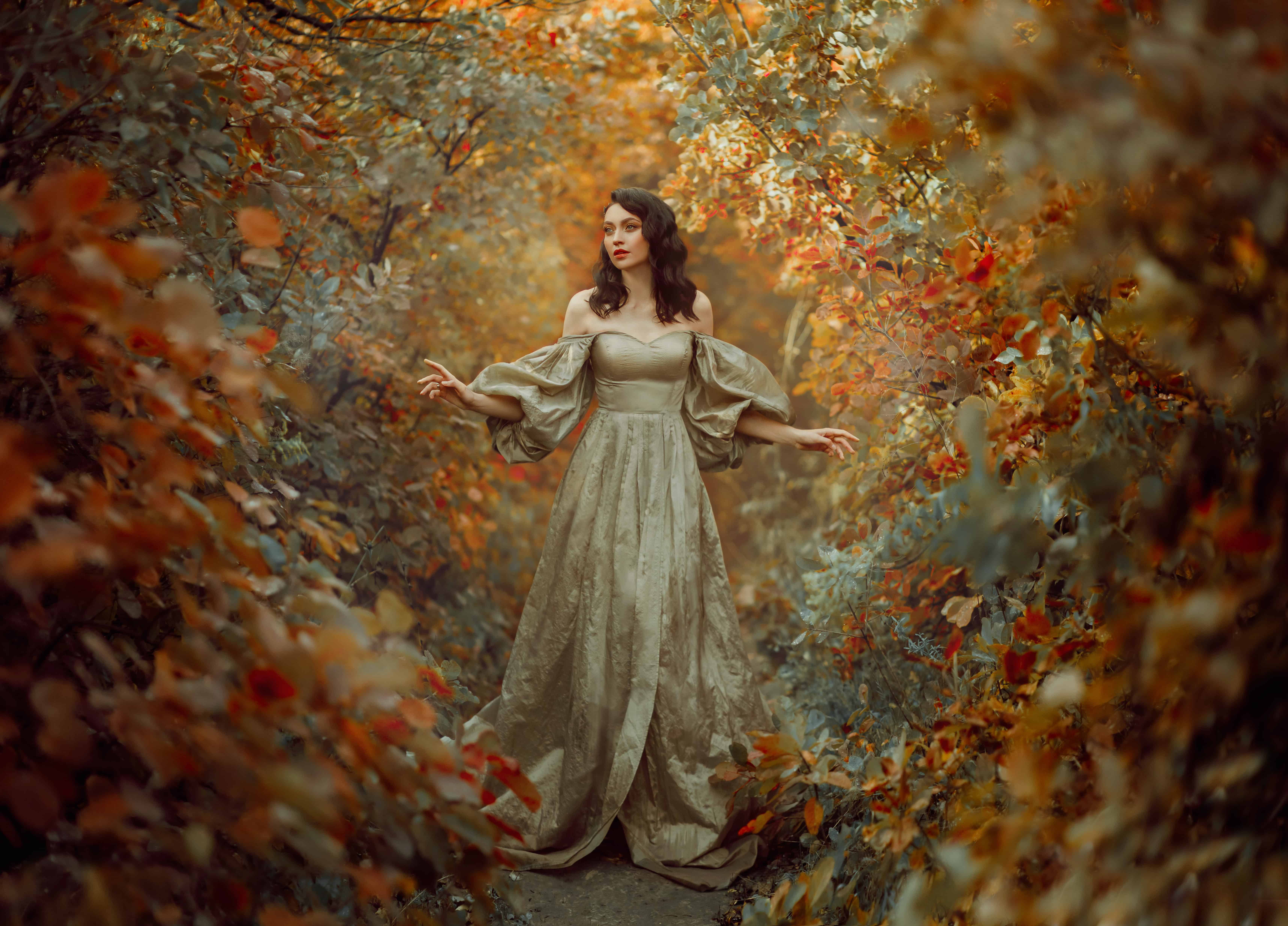 Queen fantasy woman walks in path mystical autumn forest. 