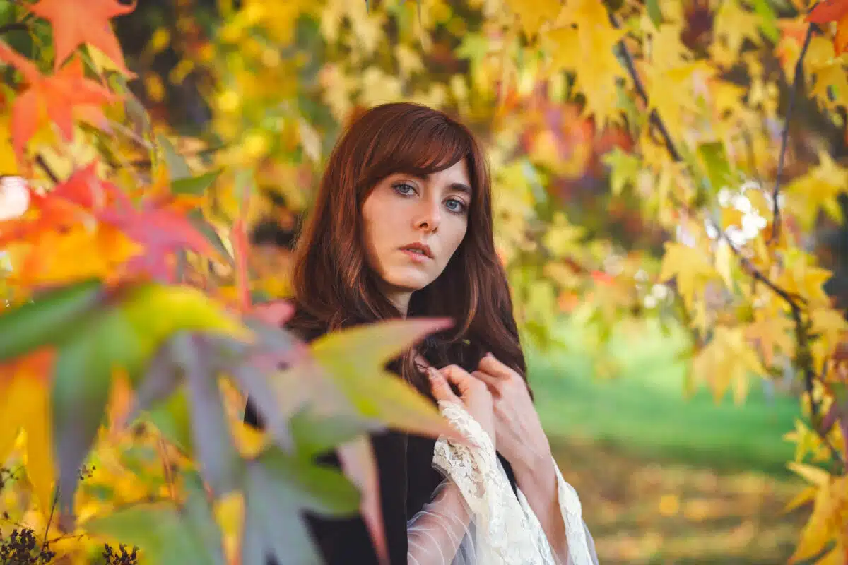 a beautiful girl standing in autumn woods
