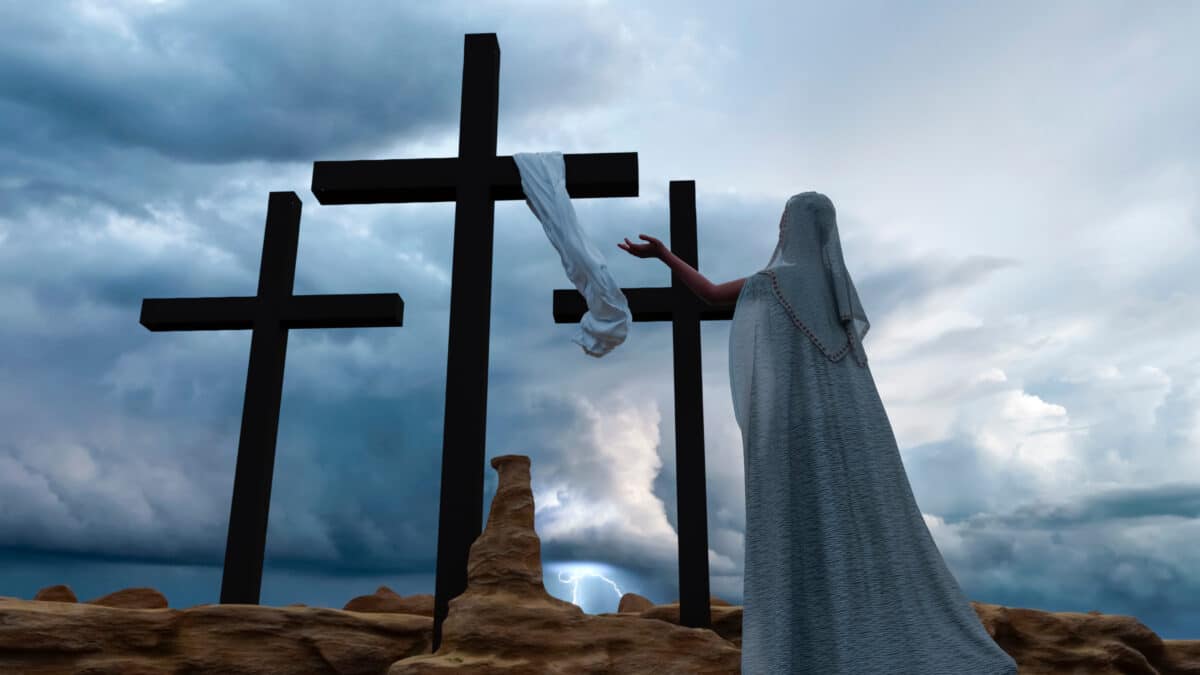 A woman praying in front of Jesus' cross during a stormy day
