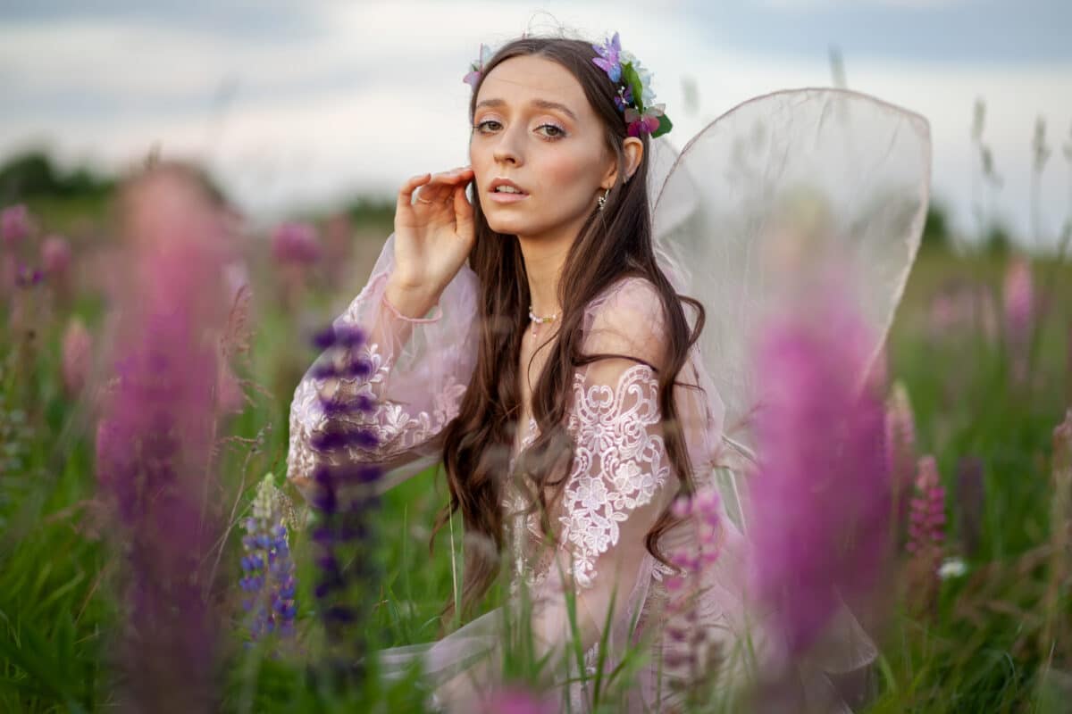 Beautiful romantic girl on nature field of flowers. Photo of sensual woman.