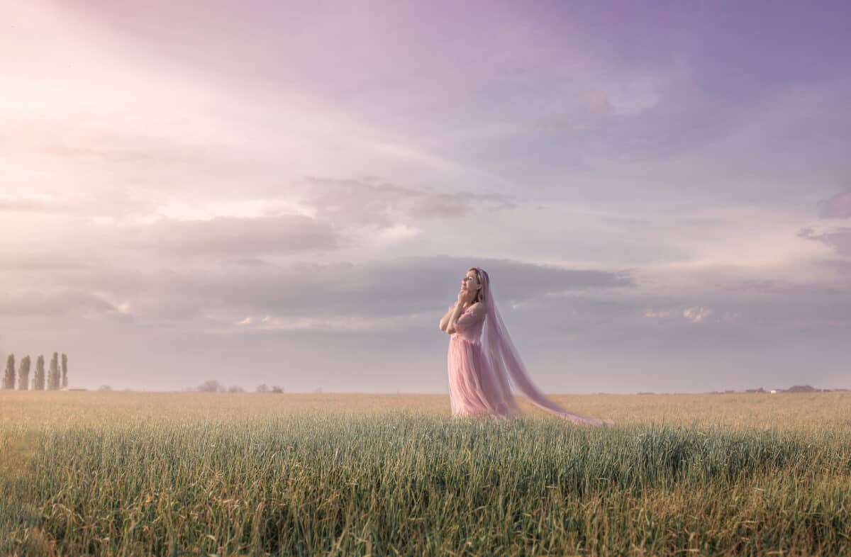 a lady on a spring field in the rays of the setting sun