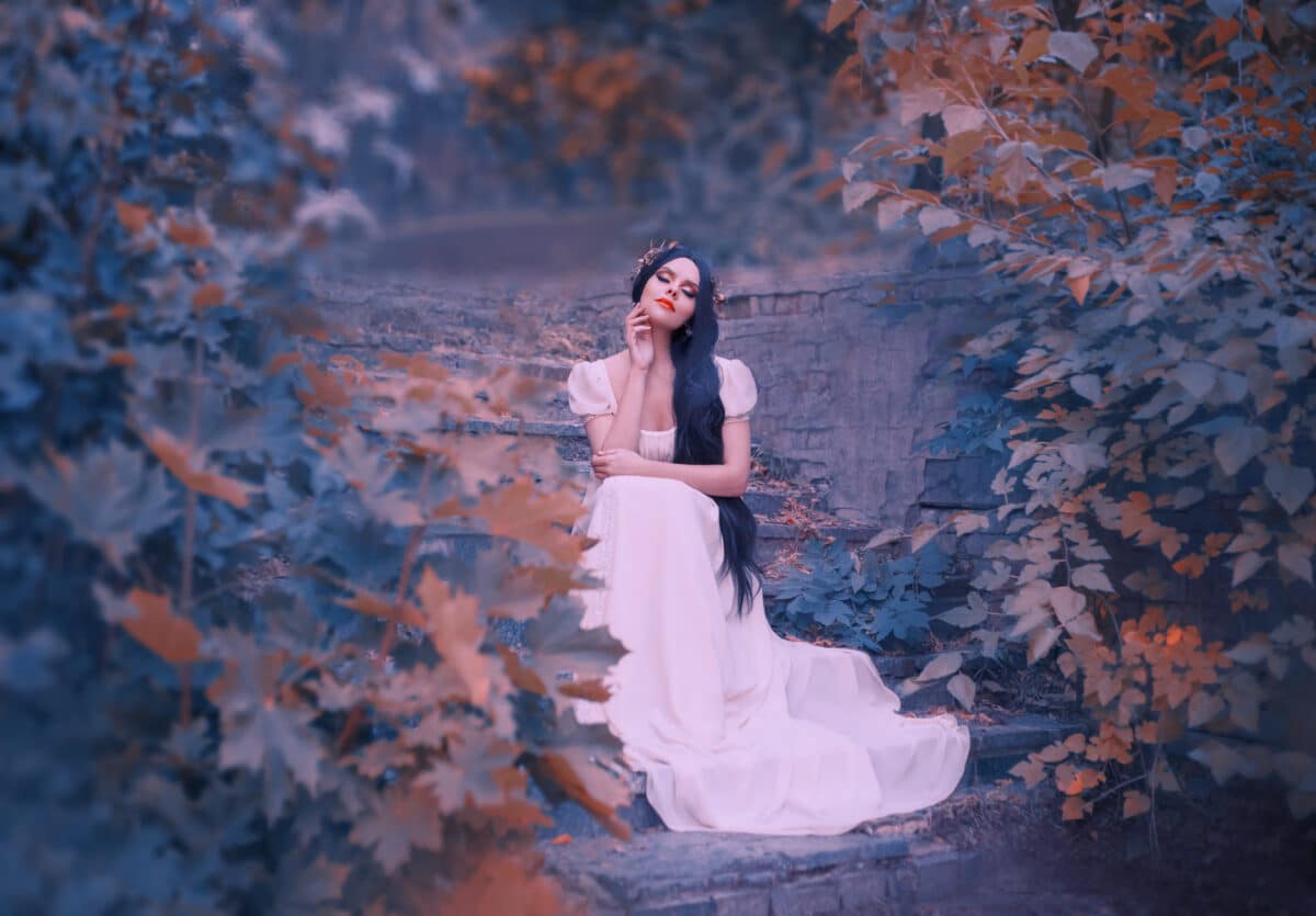 forest goddess on stone steps, dreams with her eyes closed, dark-haired girl in long white dress, elegant golden wreath on her head, the fairy-tale spirit listens to the sound of grass and leaves