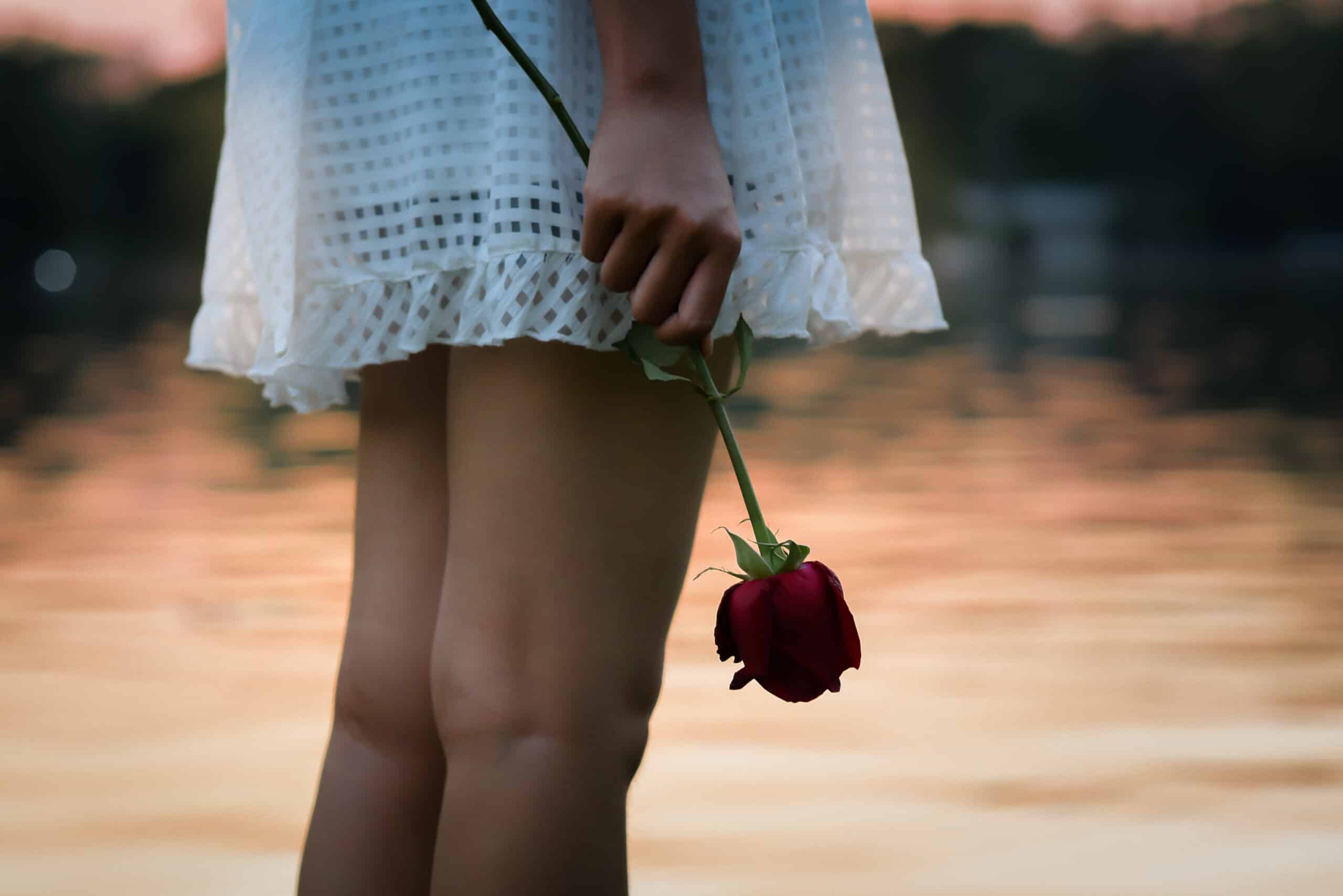 Heartbroken woman holding a rose