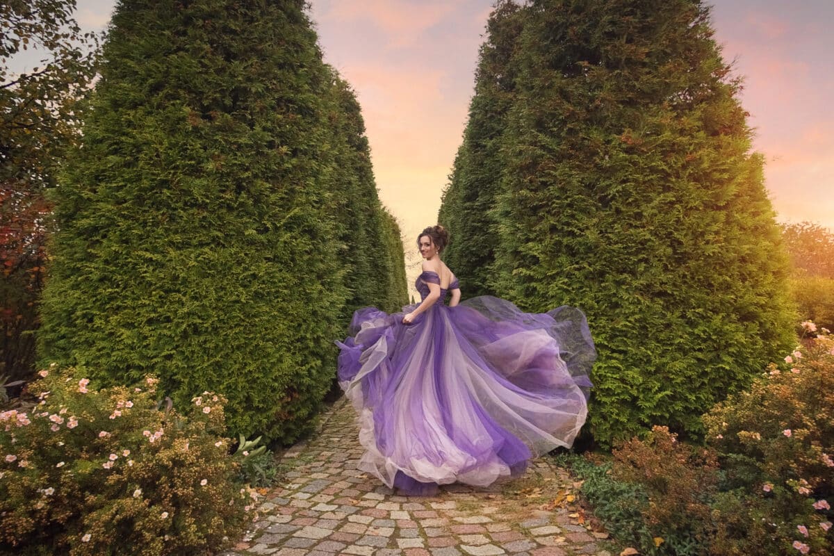A beautiful young girl in a lilac dress running down the alley o