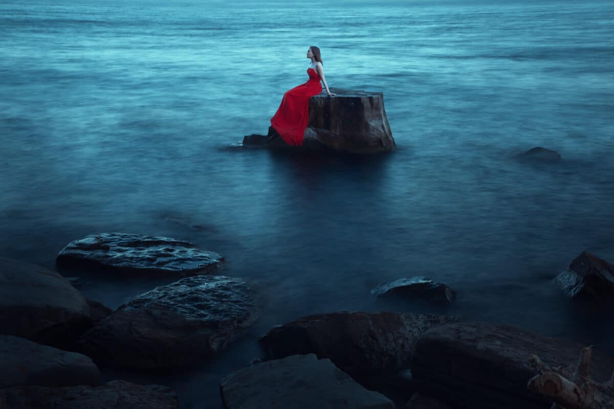 A sad woman near the sea in evening