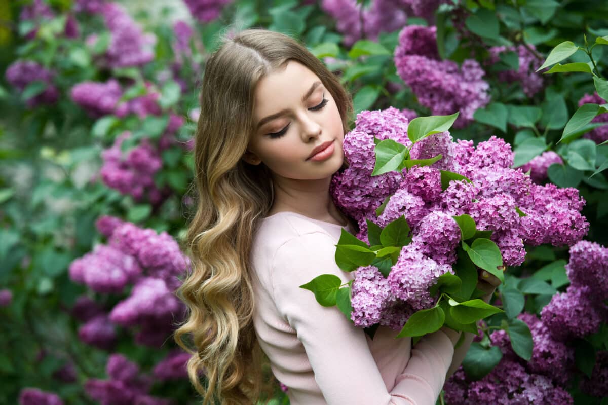Beautiful girl in lilac Garden. Girl with lilac flowers in sprin