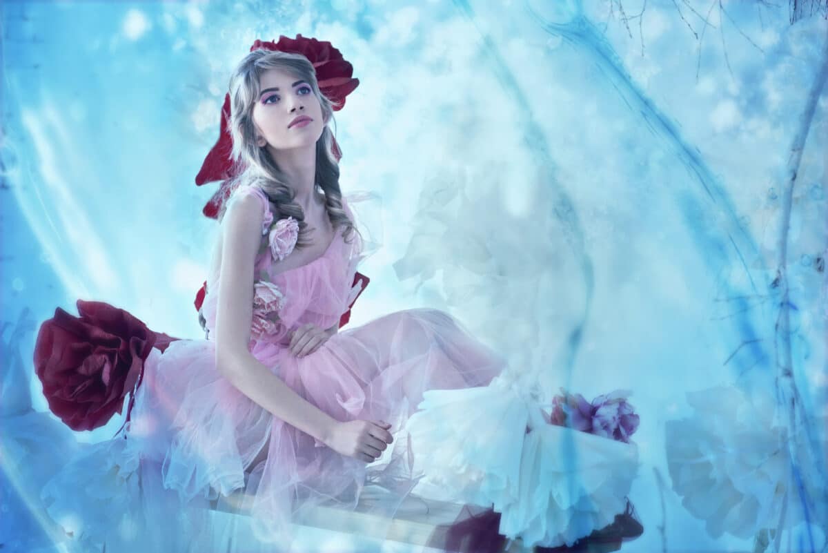 a beautiful fairy in a light pink dress sitting in a magical place