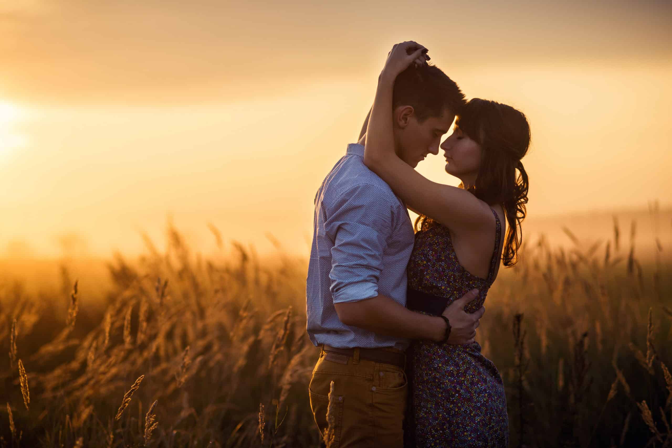 Loving couple middle of the wheat field at sunrise