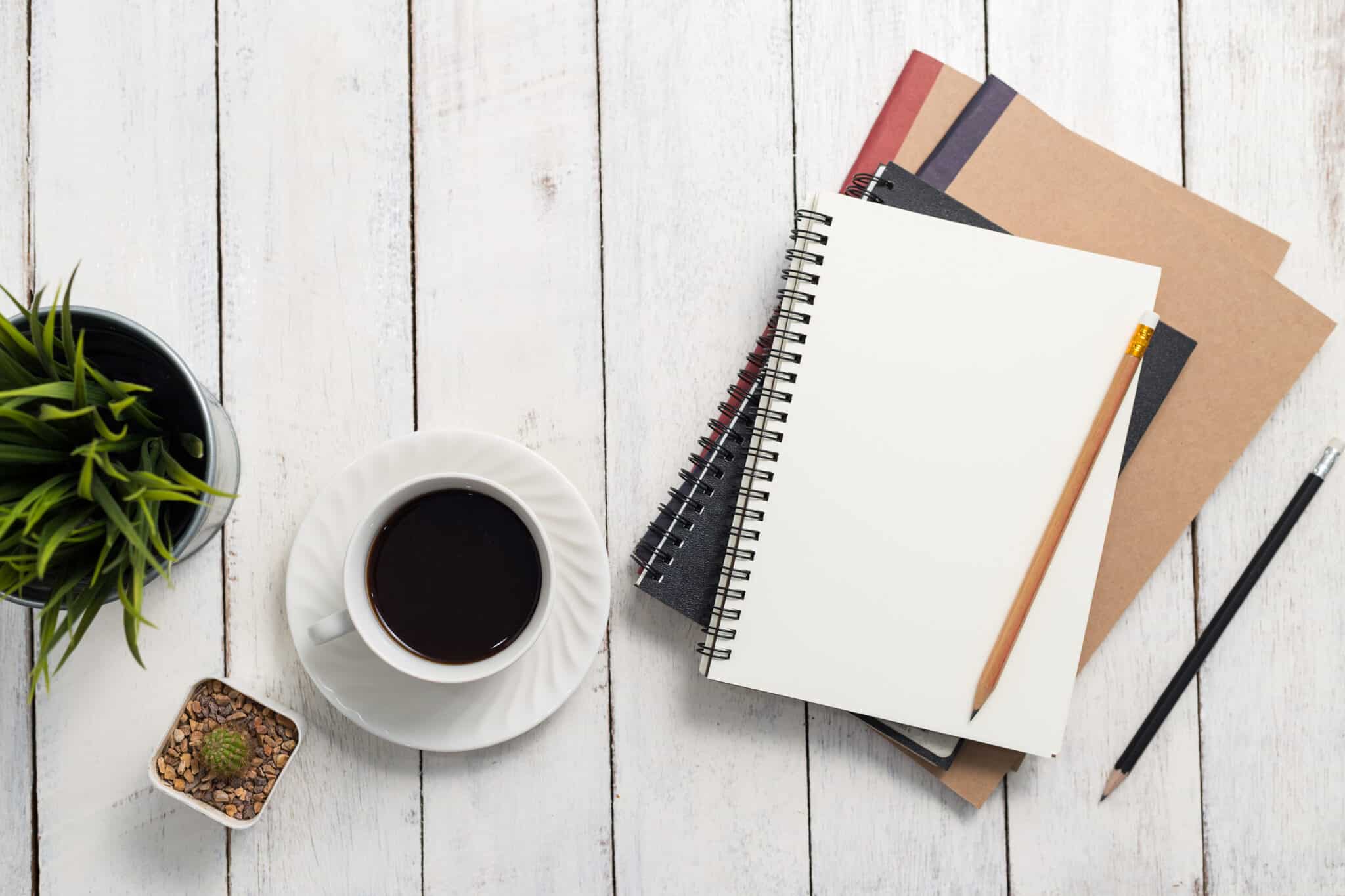Empty notebook and coffee on  wooden table
