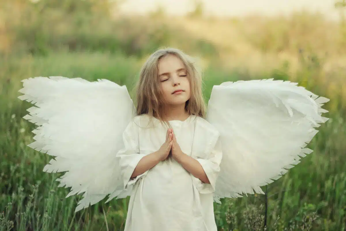 little white angel with eyes closed while praying