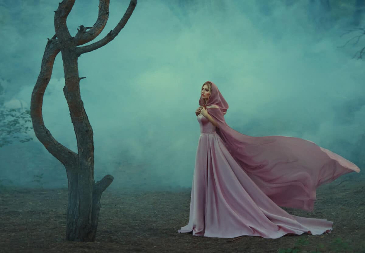 gorgeous young elf princess with blond hair, dressed in an expensive luxurious long gentle pink dress, holding a light hooded cape with her hands, a girl stands alone in a dark forest full of fog