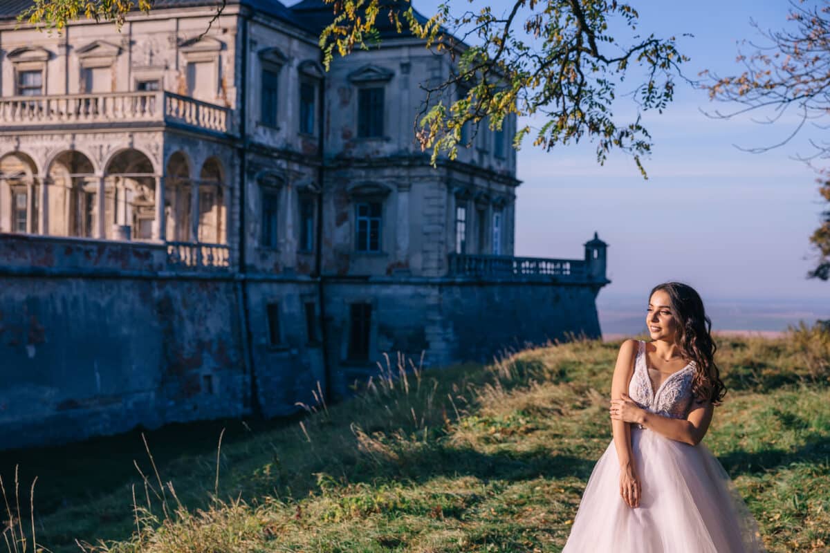 beautiful noble lady in a white dress near the castle enjoying nature