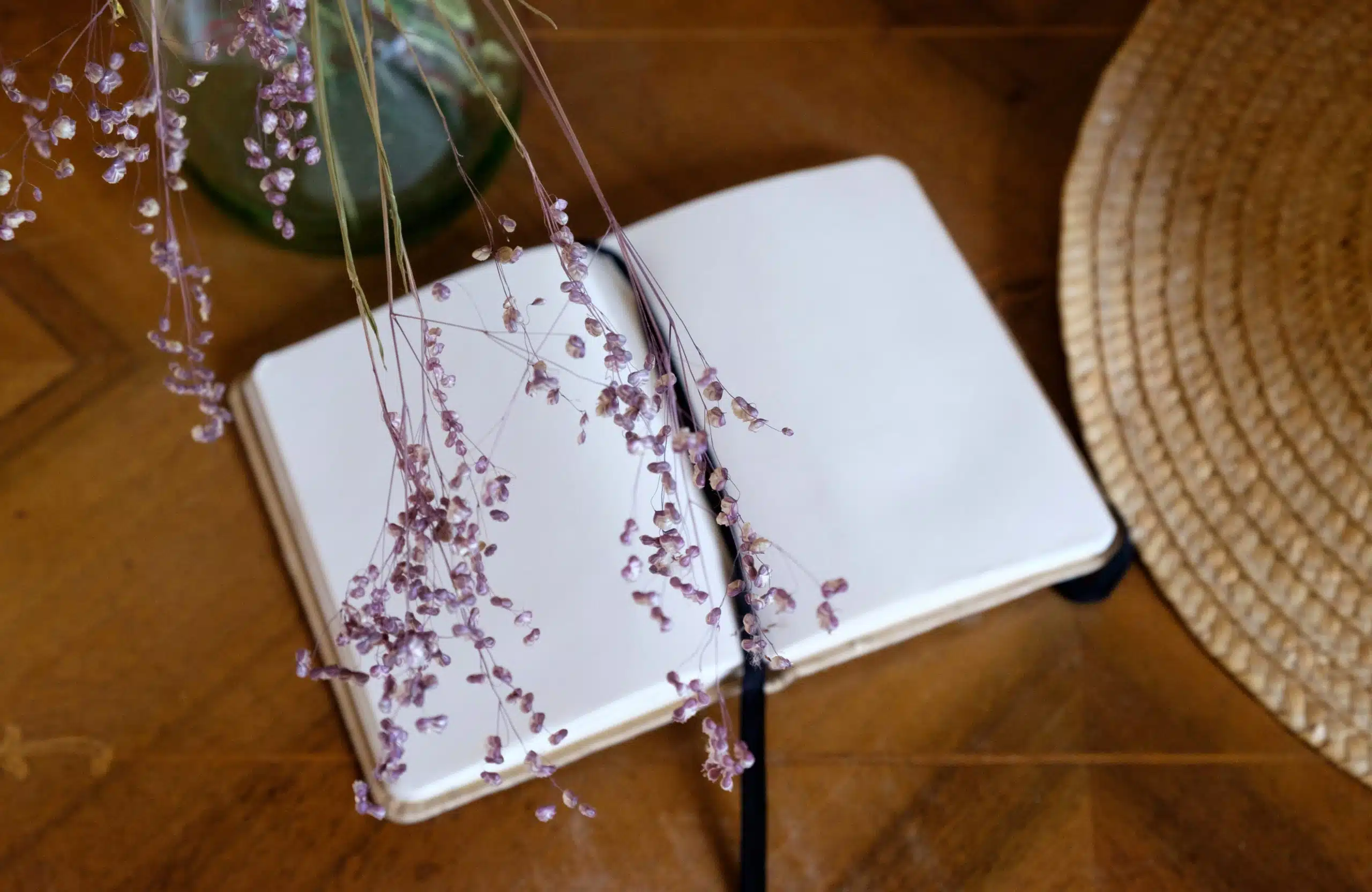 dried pink wildflowers and opened empty notebook