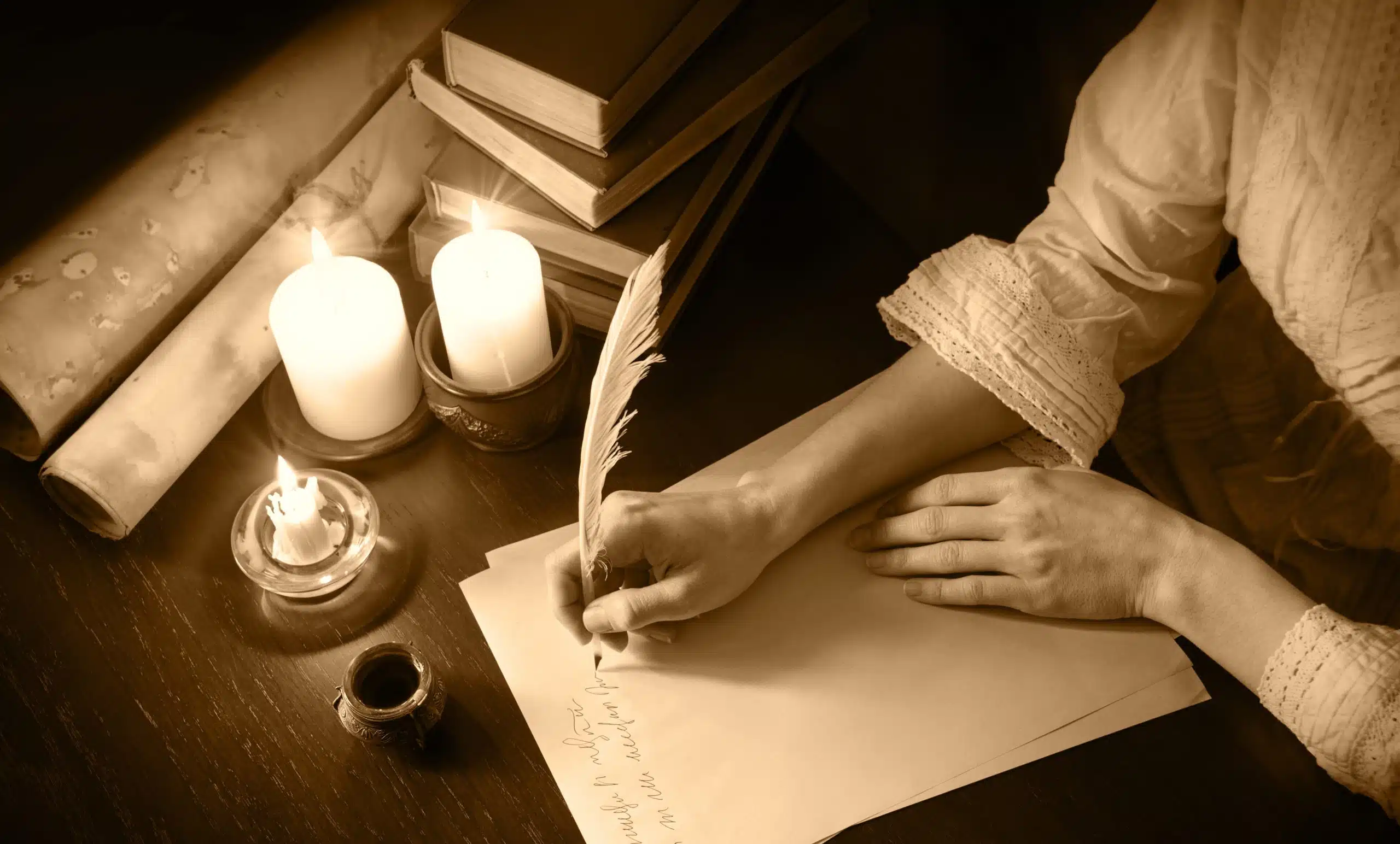 Female hand writing in vintage paper at wooden desk