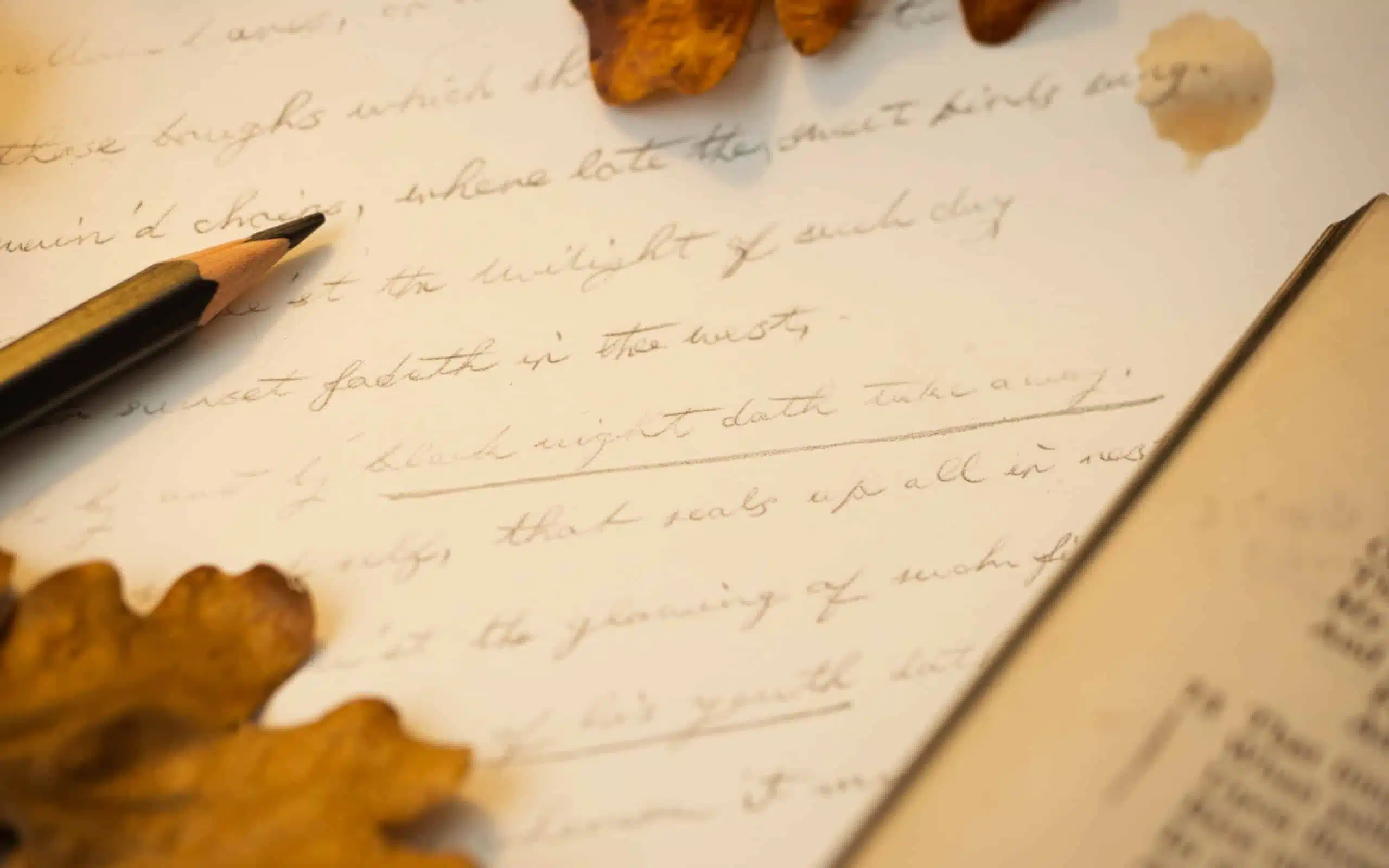 Vintage paper with Shakespeare sonnet, autumn leaves, and a pen.
