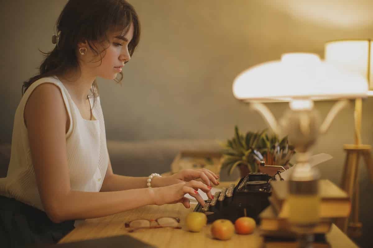 female writer working on a typewriter at home.