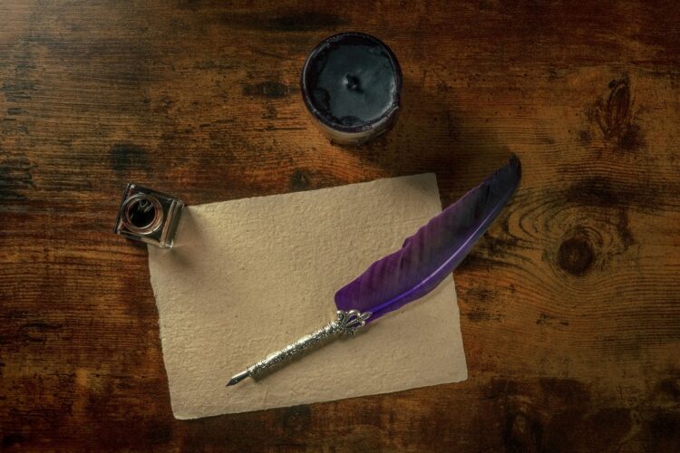 Feather quill pen with a vintage inkwell and old parchment paper