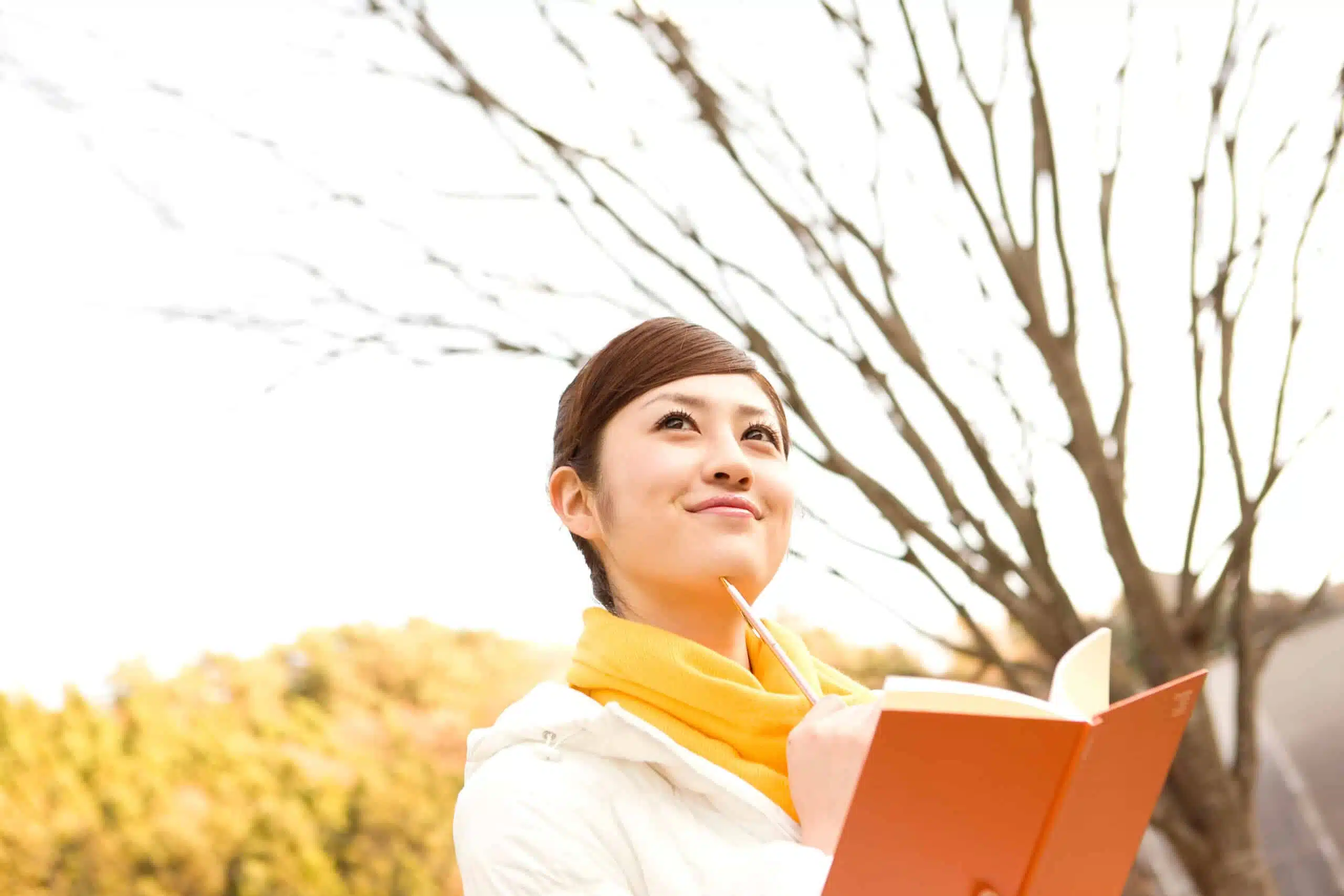 Asian woman writing outdoor in autumn