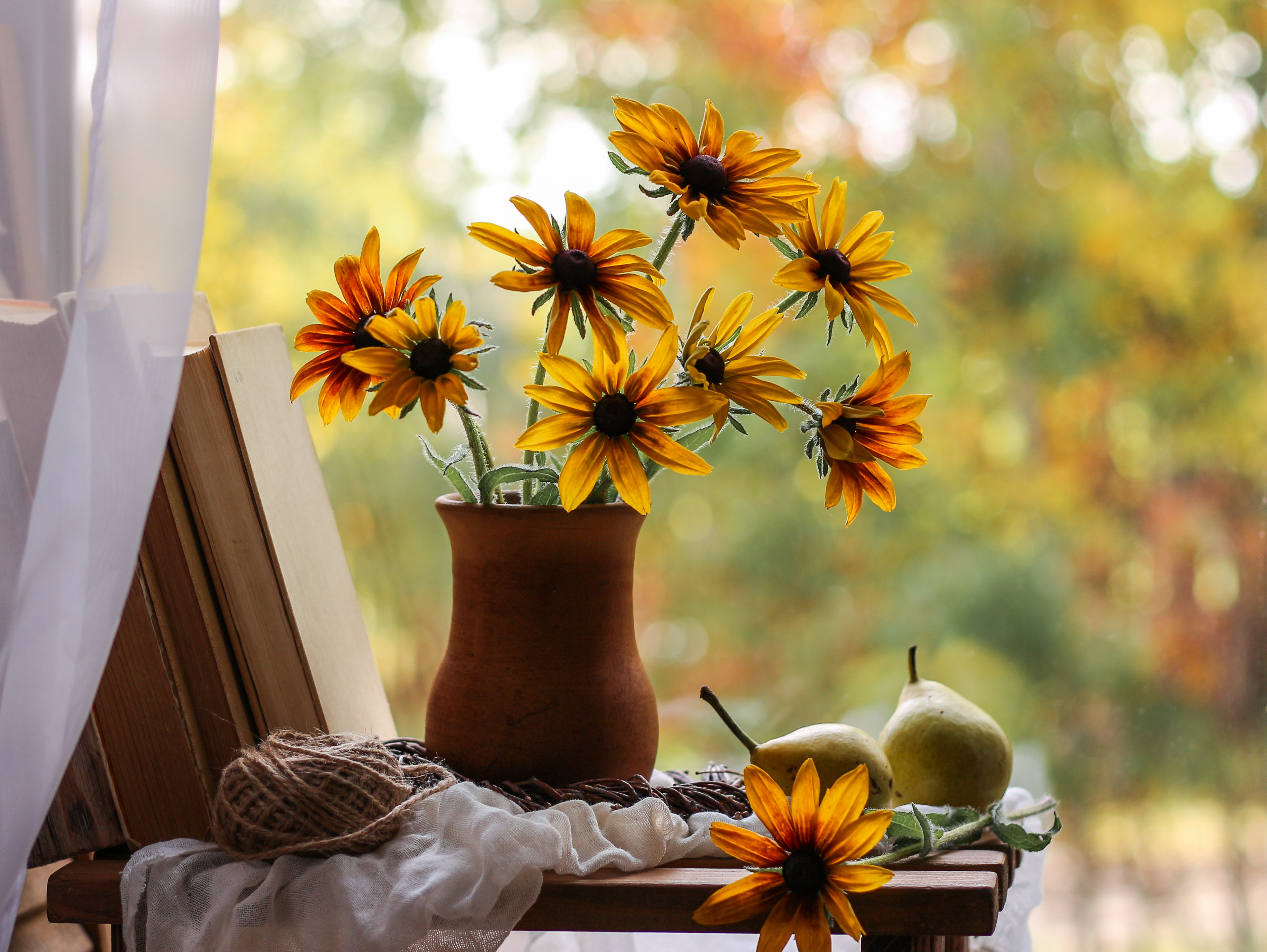 Vase with yellow flowers and books on the background of autumn nature. 