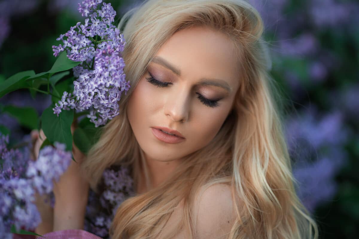 very beautiful girl in a pink top in purple flowers with closed eyes