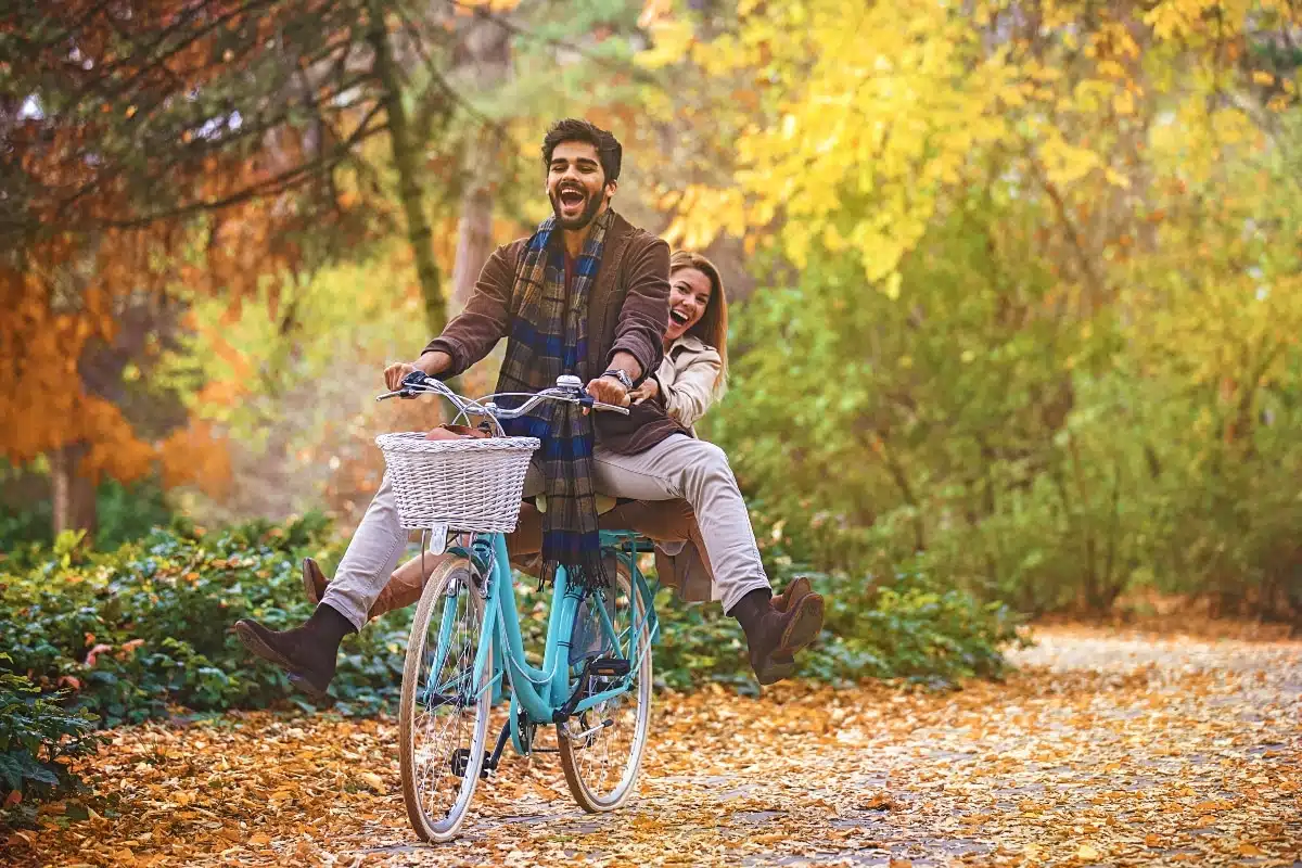 Young smiling couple enjoying fall in the park.