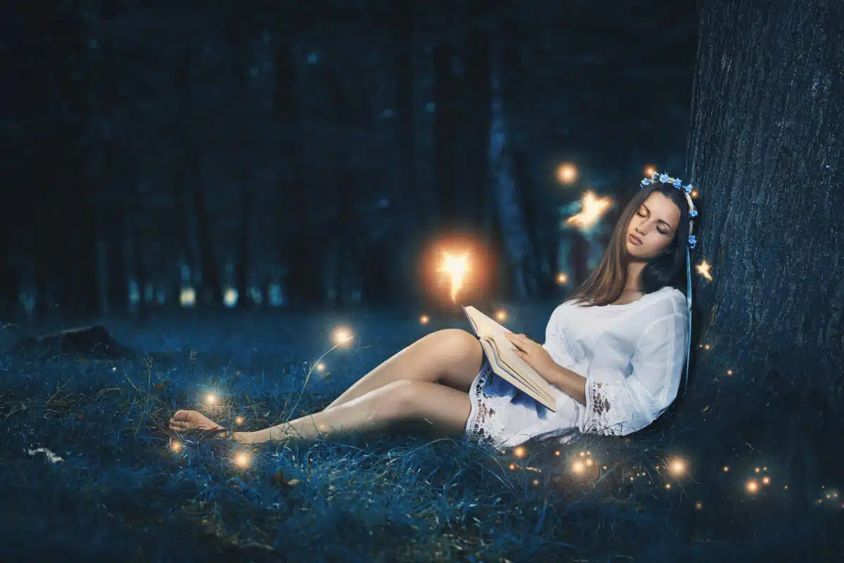 Beautiful woman sleeping among fairies