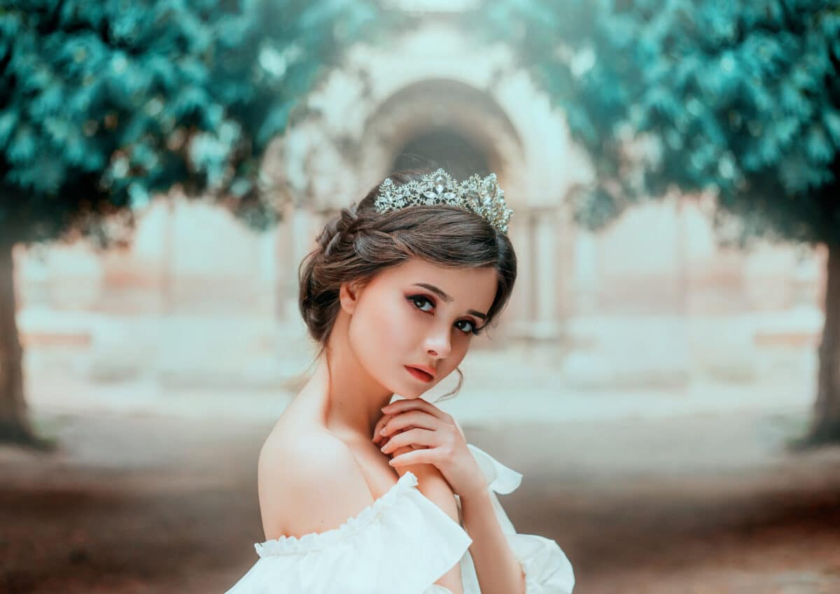lovely tender girl with perfect skin and dark magnificent eyes, wonderful work of hairdresser and gathered brown hair with silver tiara, light natural make-up, portrait photo and creative colors