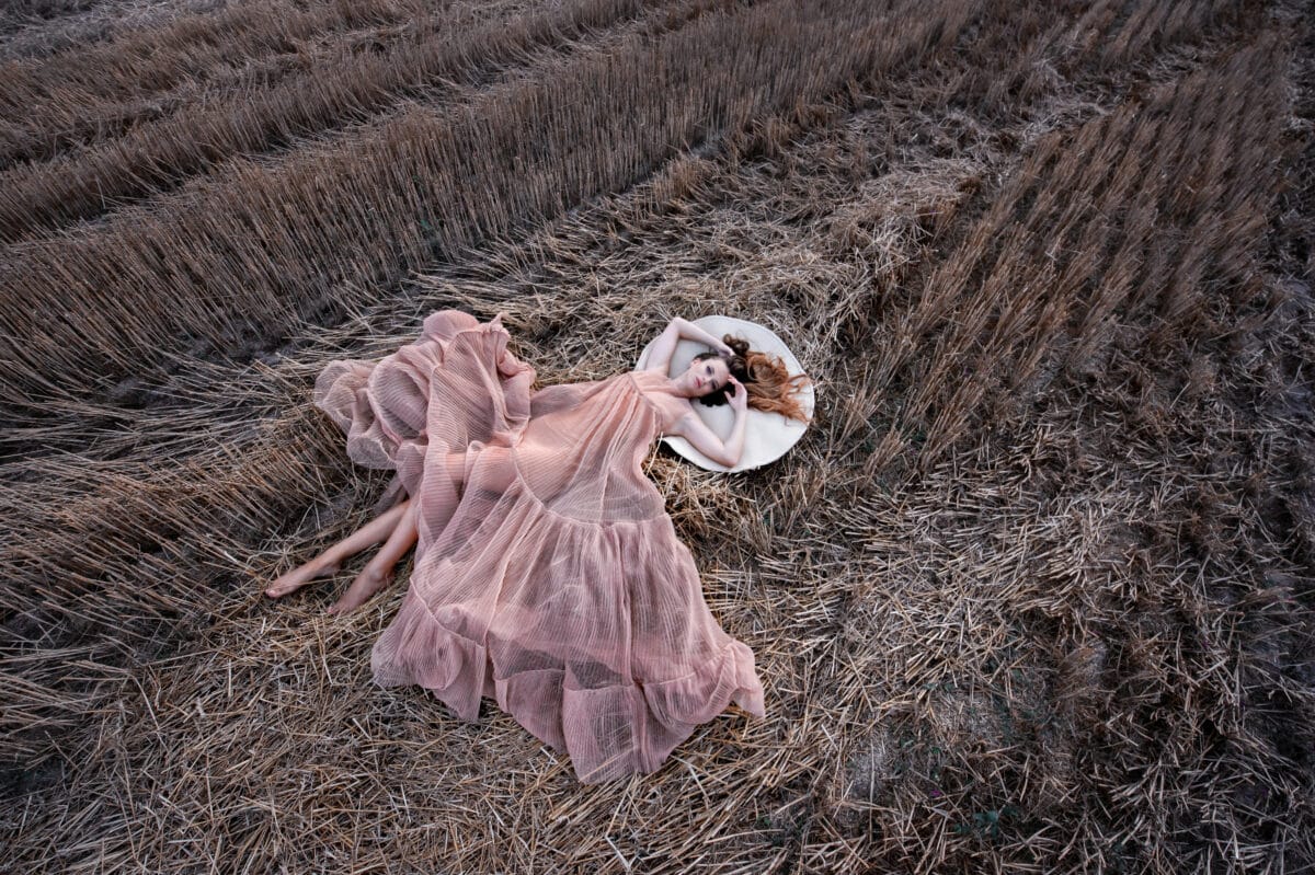 Beautiful girl in a field on a hay. Girl in amazing dress
