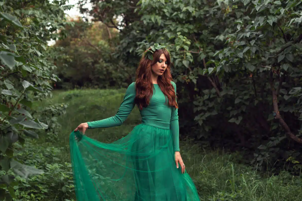 a young woman in green dress in the garden