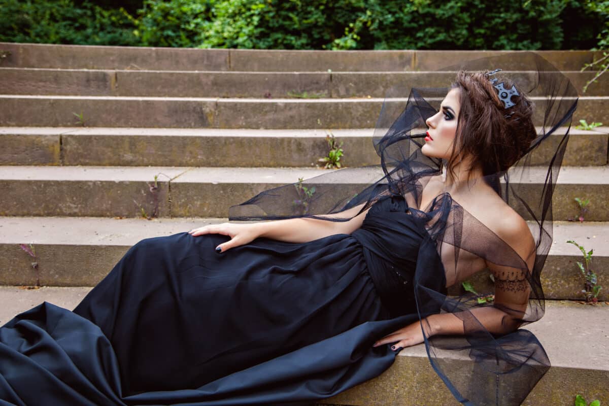 Dark queen in veil lying on the steps of palace