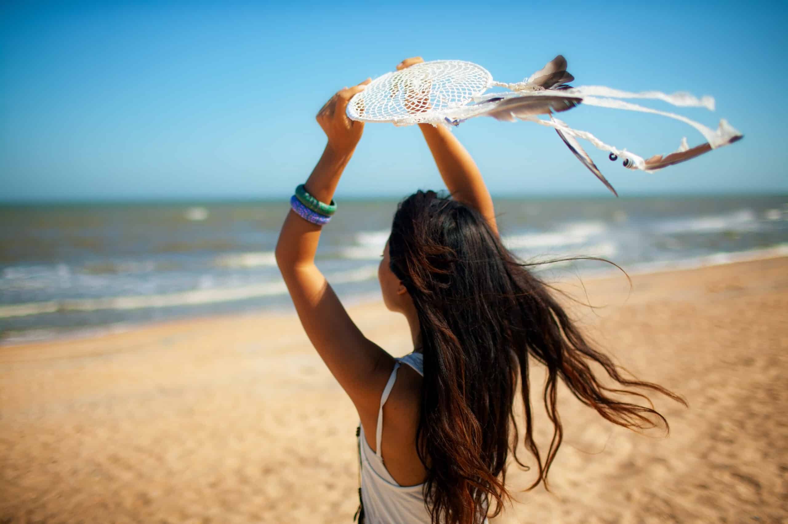 beautiful girl young woman in white dress on the beach with dreamcatcher