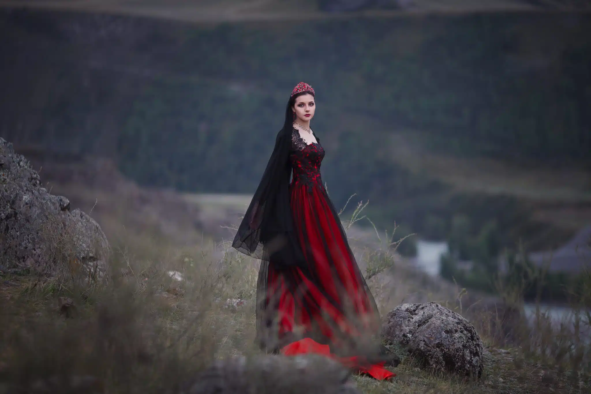a girl in a royal red gown on a mountain
