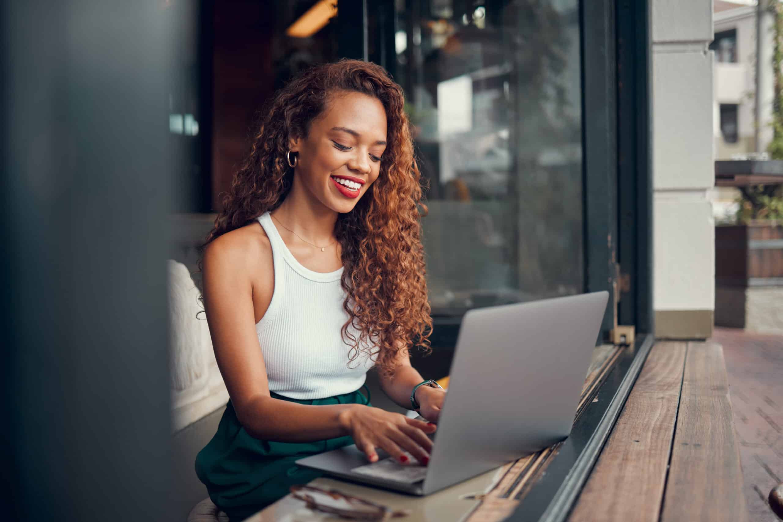 cheerful and attractive afro woman working on her laptop