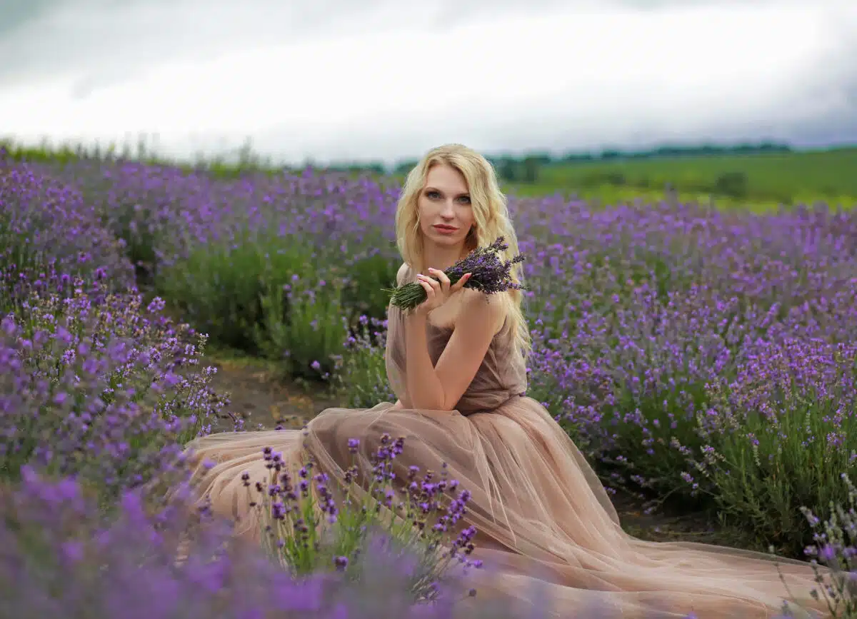 blonde girl in lavender field in summer enjoying vacation