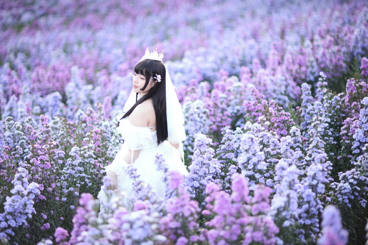Beautiful young woman with white Lolita dress with European garden Japanese fashion