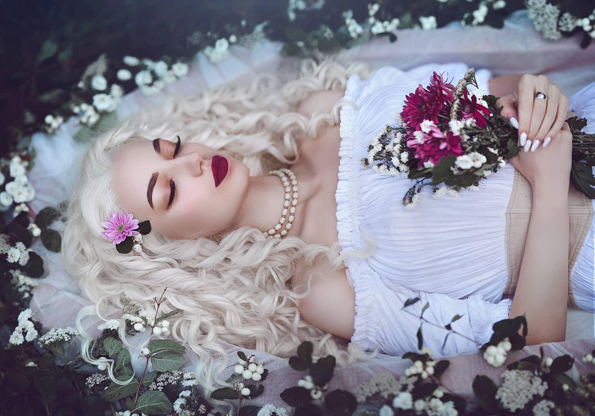Sleeping beauty. Enchanted Princess lies in a coffin in flowers with a bouquet. 