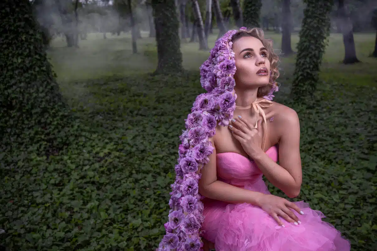 Beautiful woman with flower cloak in ivy forest