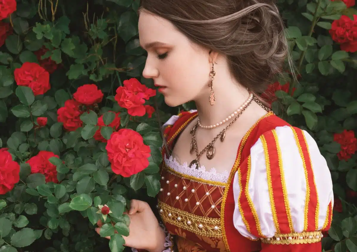 a sad victorian princess smelling the roses in the garden