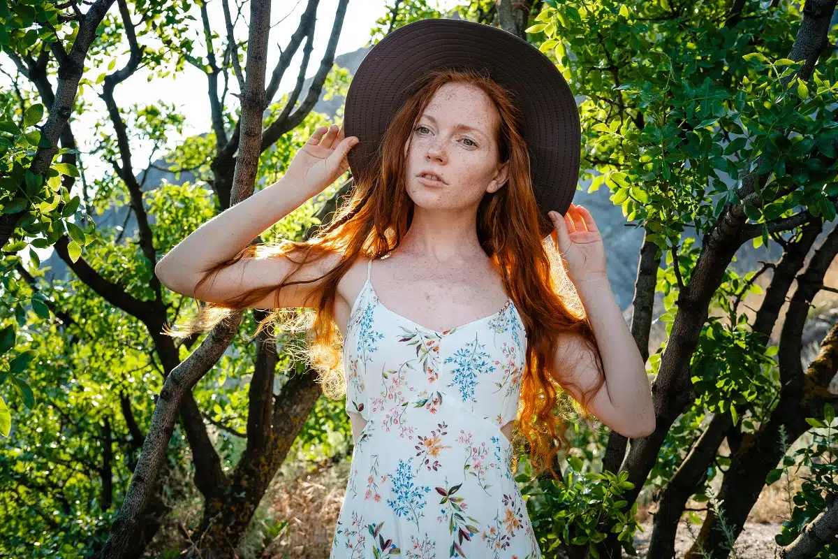pretty and tender red haired woman with a pensive mood in the woods