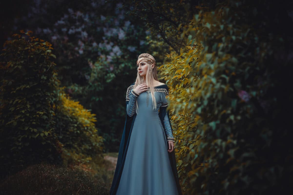 The beautiful elf in a long blue dress is walking in a green forest full of branches, ,Princess in vintage dress, the queen of the forest,fashionable toning,creative computer colors