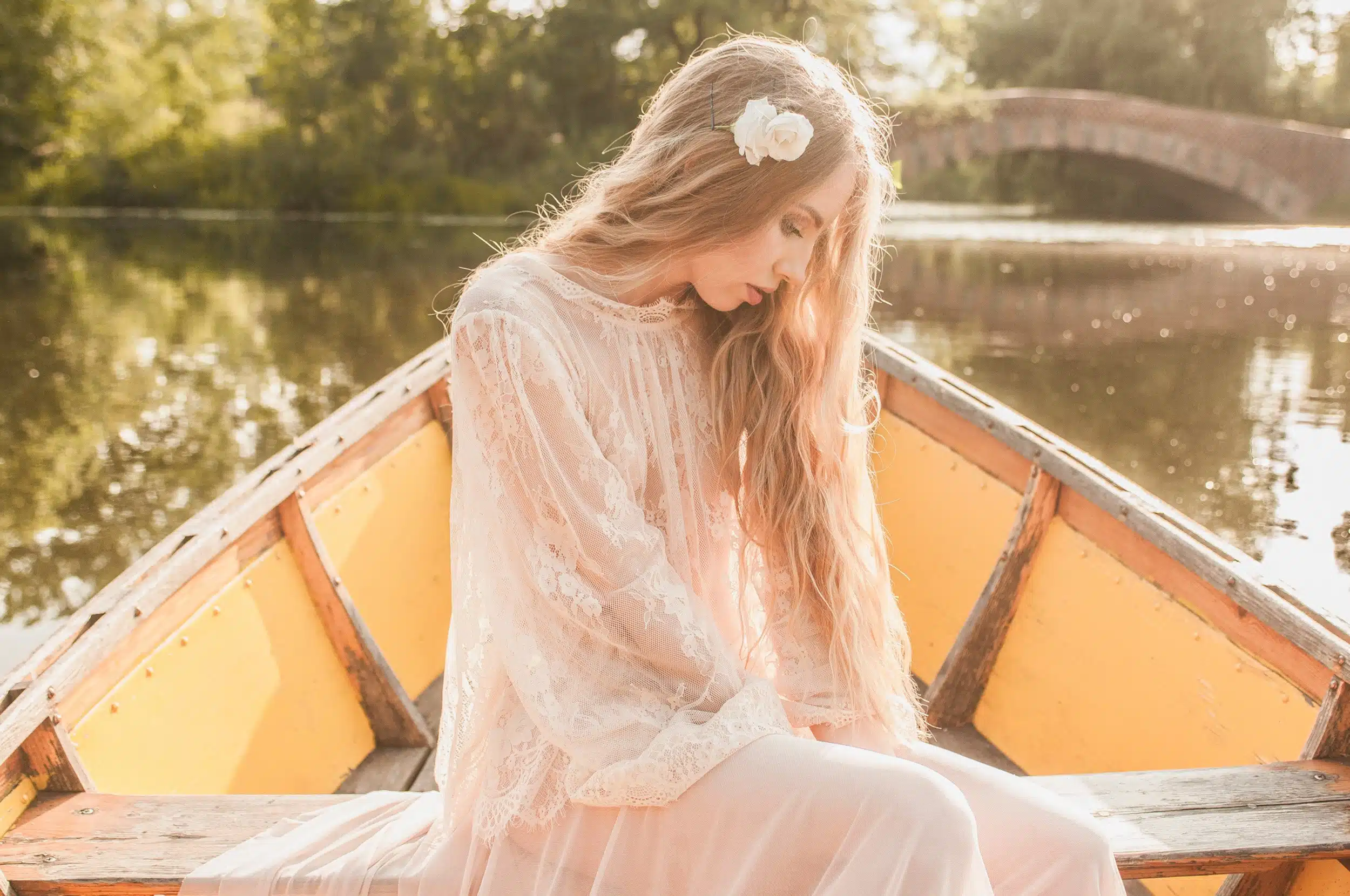 Enchanting melancholic woman in dress alone on a paddle boat.