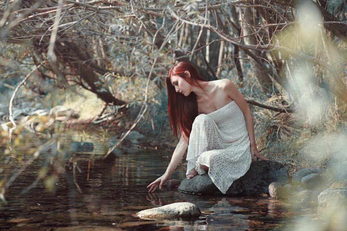 Woman touching water in a stream