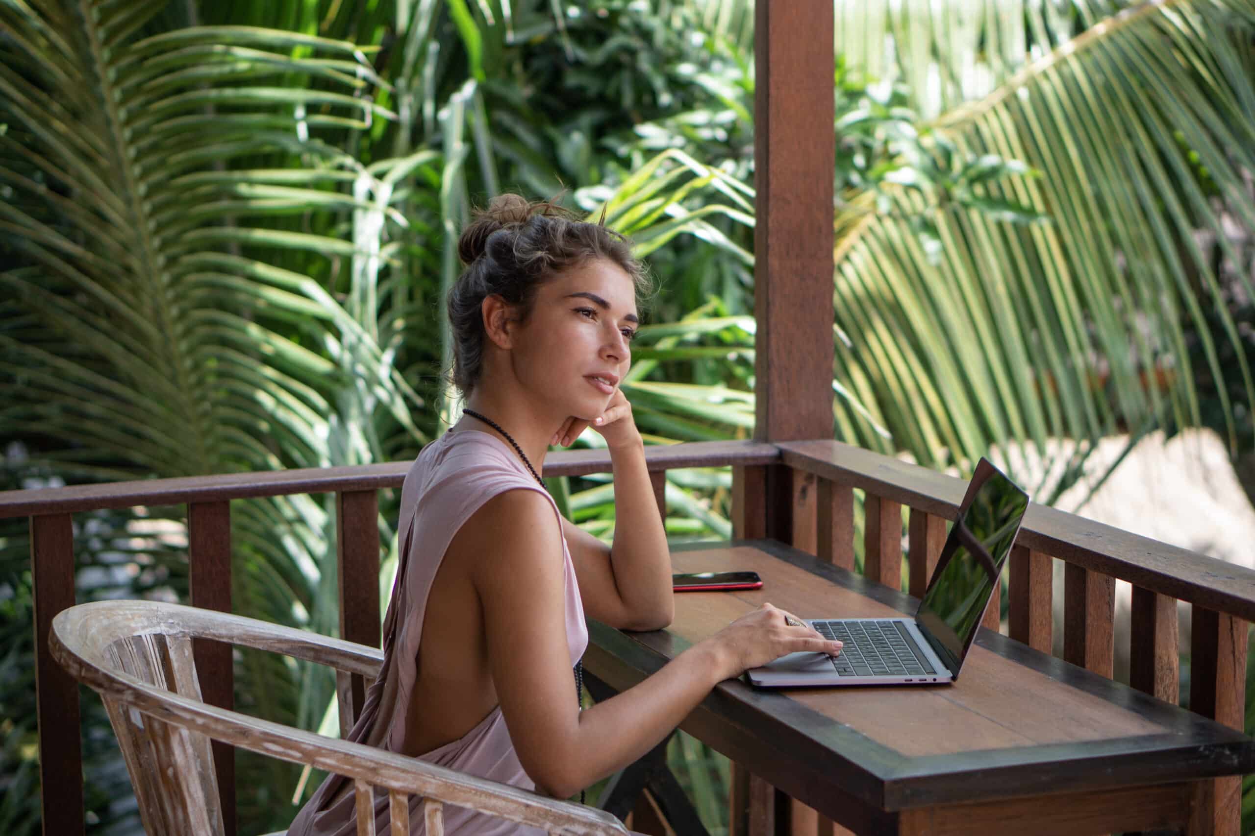 young beautiful writer working with laptop in a tropical hut
