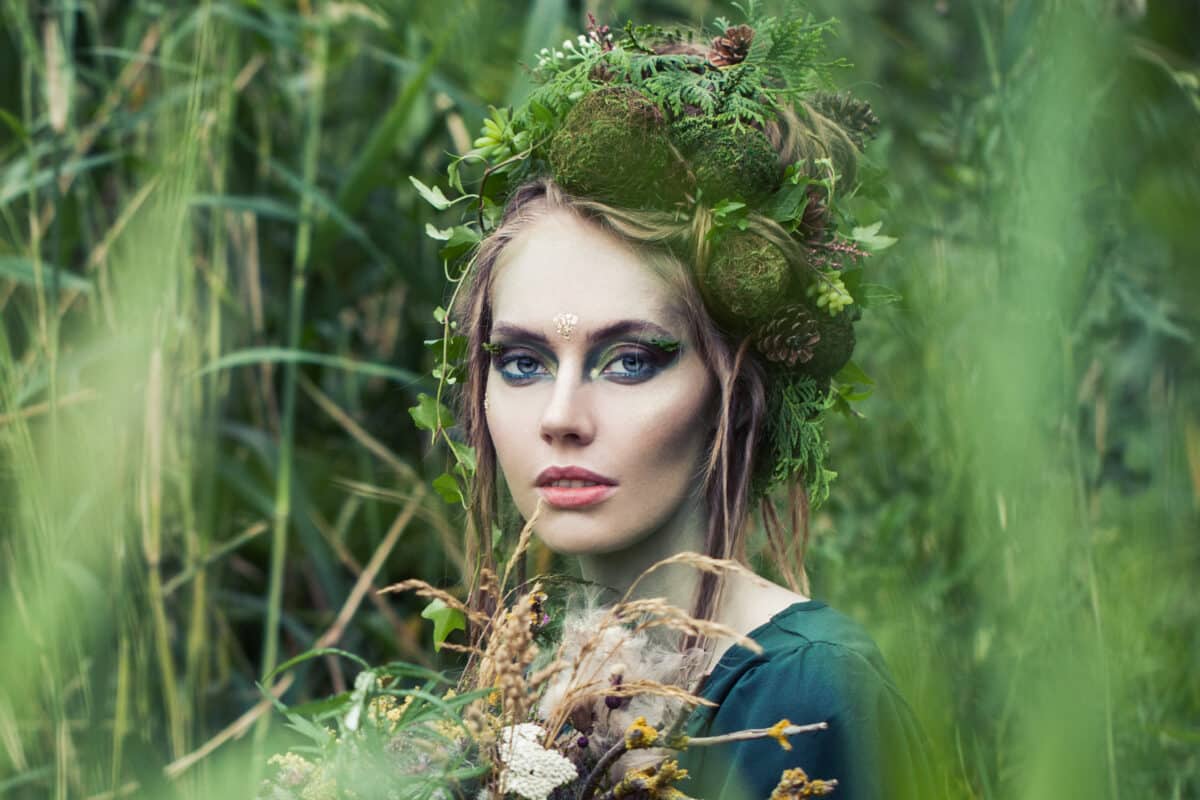 Forest portrait of fairy nymph woman in green grass outdoors