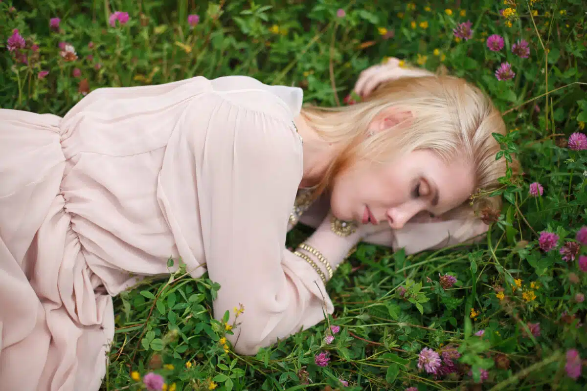 beautiful lady lying on a blooming field