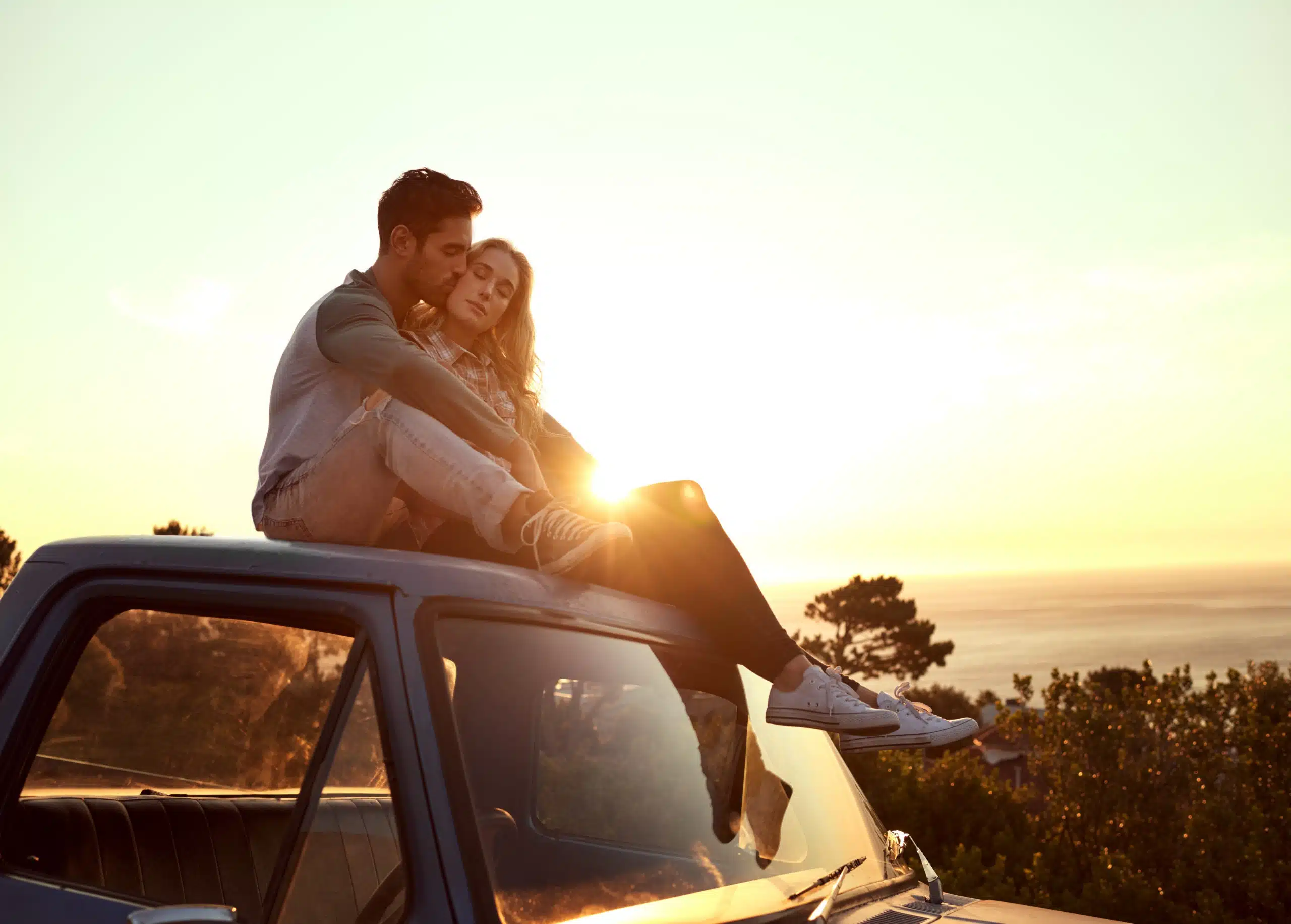 Romance on the road, affectionate young couple enjoying a road trip together.