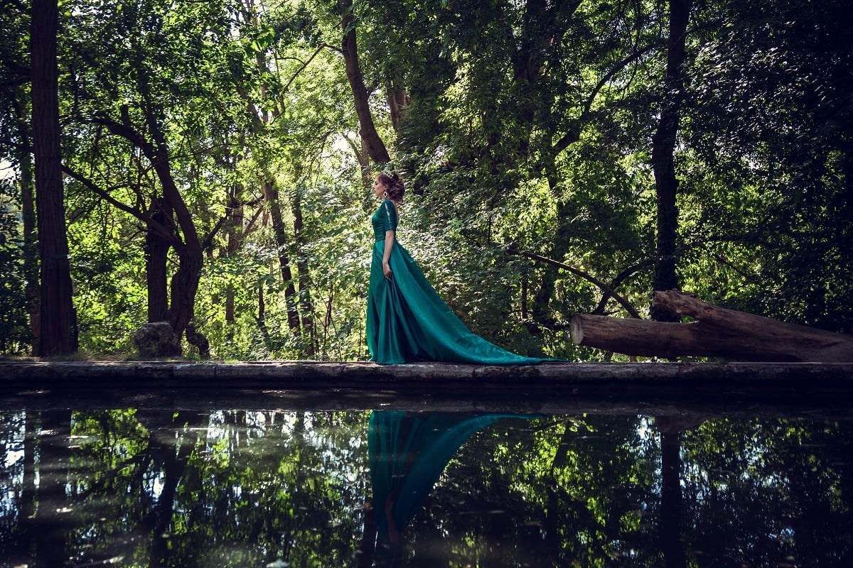 noble lady walking on a path by the crystal clear river