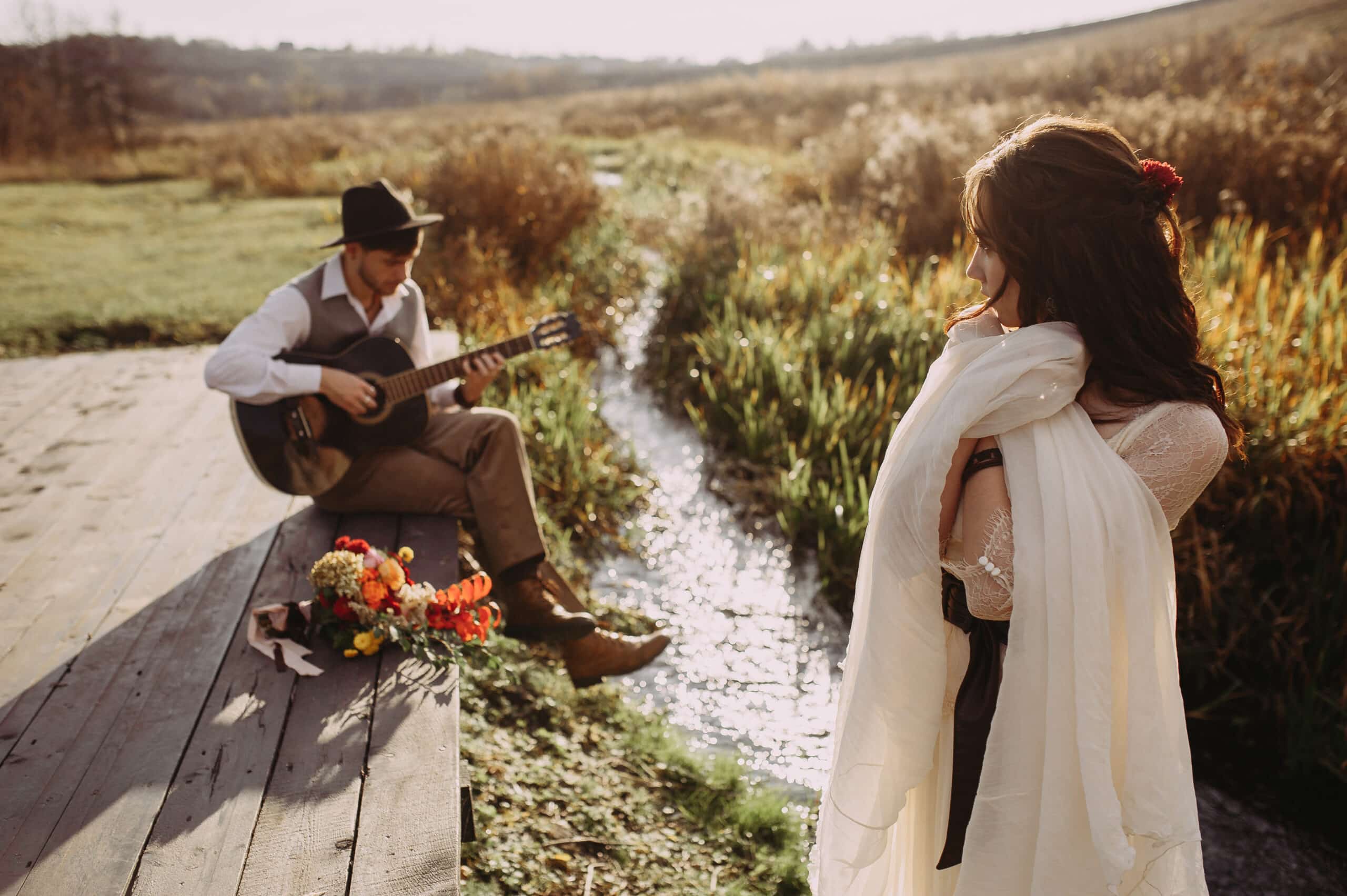 bride and groom on the background of the river. plays the guitar