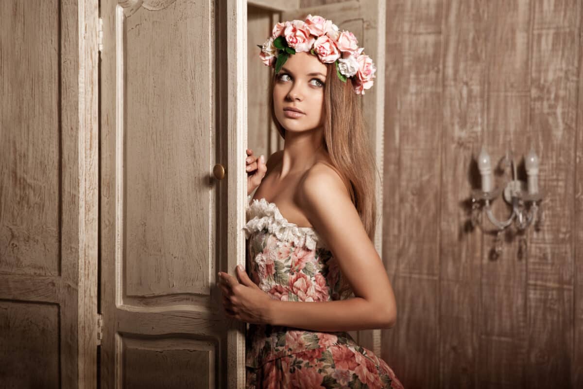 a young lady is dressed in elegant vintage floral dress with flower head wreath